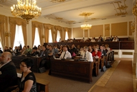 Pozorně naslouchající účastníci ve vzdálenější části sálu